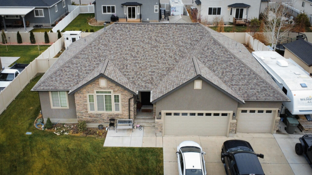 Roof Repair in Kaysville - UT underway as a roofer seals flashing around a roof vent