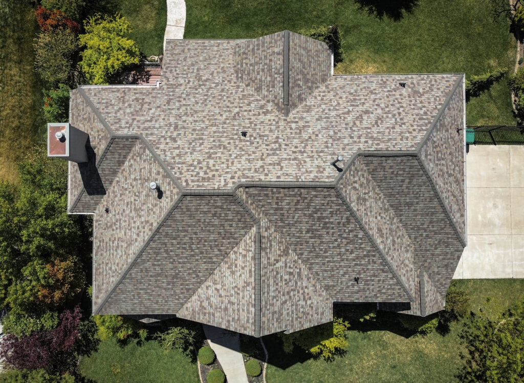 Roofing Contractor in Syracuse - UT examining flashing near a chimney after windy weather, Roof repair technician in Midway - UT examining shingle wear and flashing near a dormer window