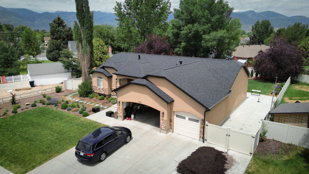 Roof Repair in Layton - UT underway as a crew seals storm-damaged flashing near a roof valley