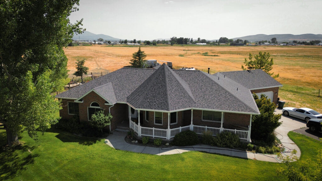 Roof repair specialist in Heber City - UT checking flashing lines and shingle seams on a steep home