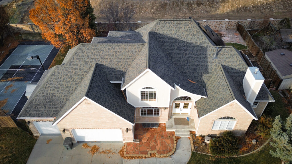 Roofing Contractor checking roof flashing on a Layton - UT home during a seasonal inspection