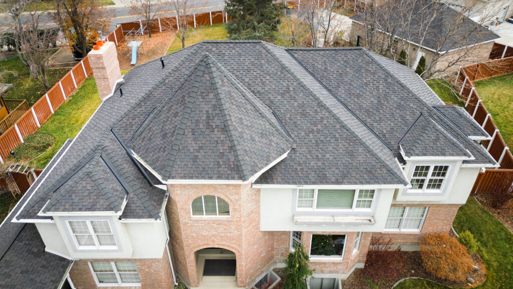 Roof Repair in Clearfield - UT in progress as a roofer replaces damaged shingles near flashing