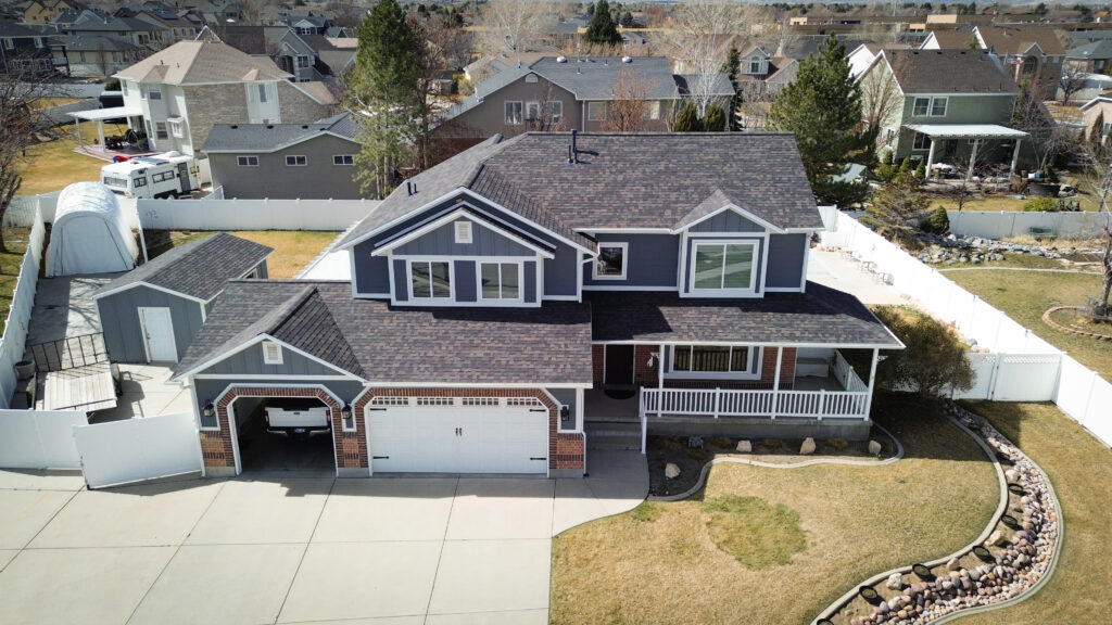 Roofing Contractor reviewing shingle condition on a Bountiful - UT hillside home roof